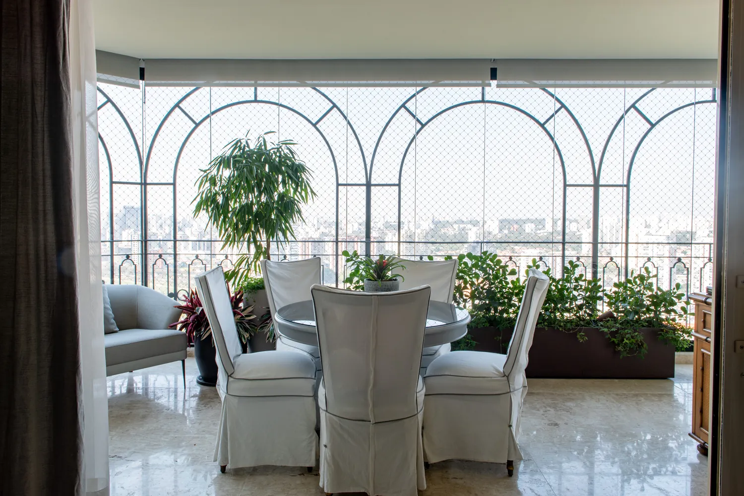 Varanda com arcos, mesa de jantar e vista da cidade, Apartamento Carla