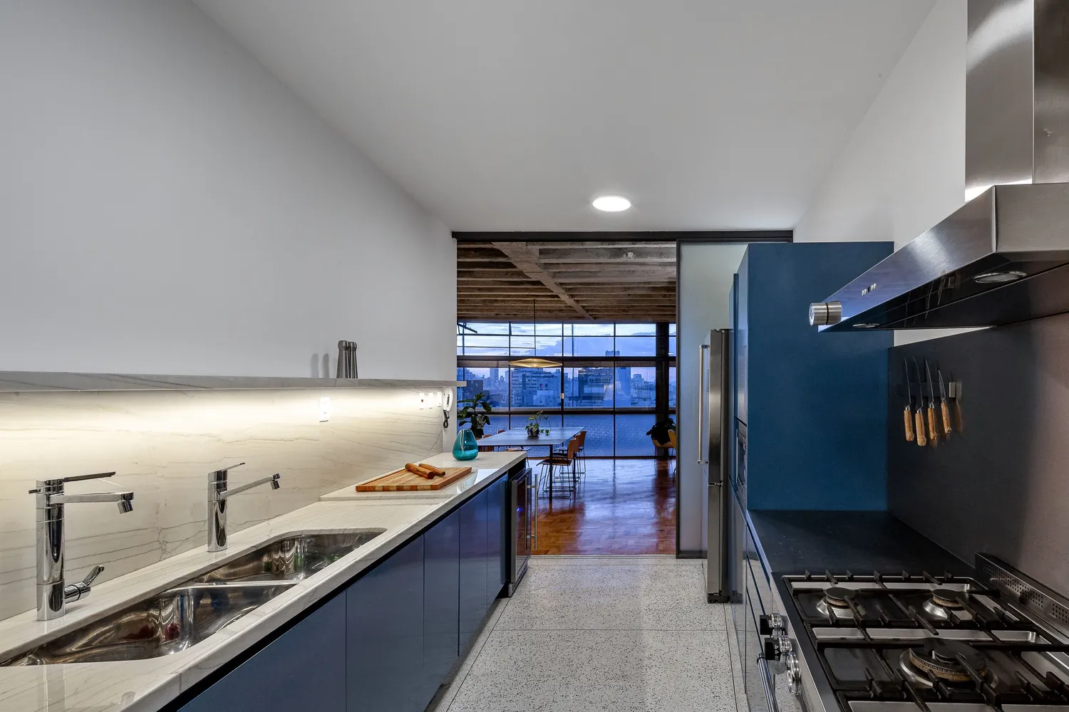 Apartamento reformado com cozinha azul, marcenaria e piso de tacos
